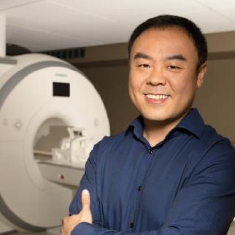 dr yao wearing a blue shirt with a machine in the background