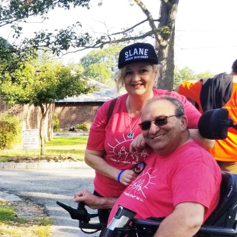 Photo of a man in a wheelchair and a woman standing next to him 