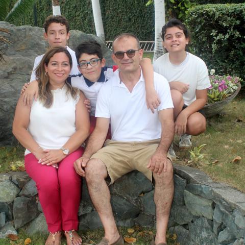 Carla Vicari sits with her family in a garden portrait