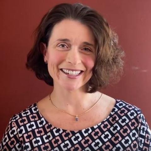 Dr. Nancy Chiaravalloti smiling against a burgundy background 