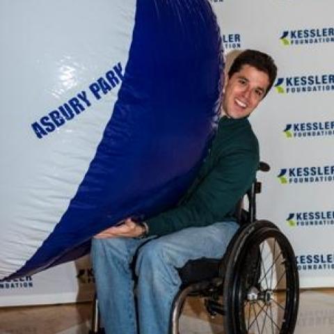 man in wheelchair holding a ball