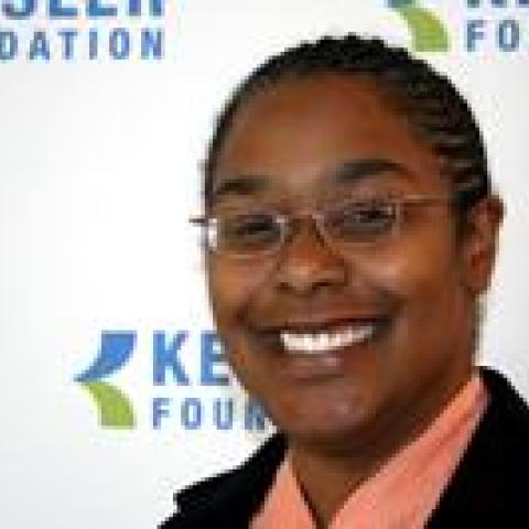 Denise Fyffe Smiling for the camera she is front of the kf logo