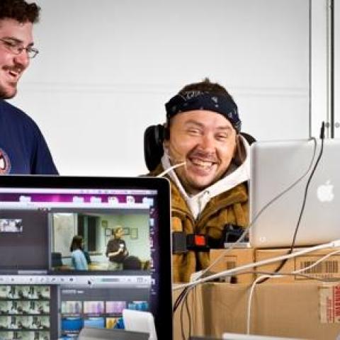 people with disabilities working on laptop computers while smiling. 