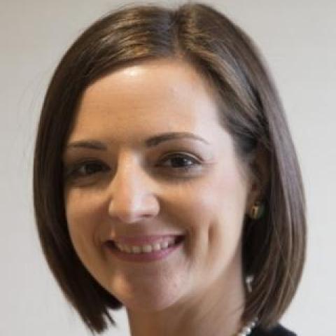 dr genova wearing a pearl necklace and black jacket