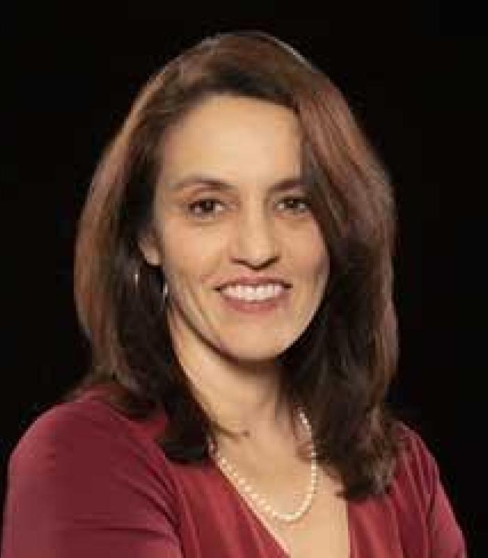 Director wearing a red blouse smiling for the camera