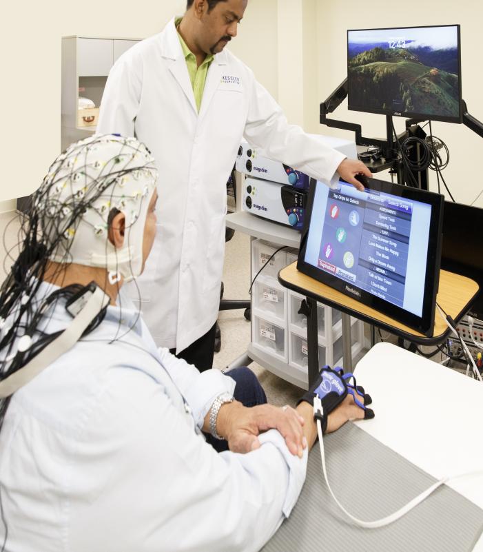 Researcher and participant during a study session using brain stimulation equitment.