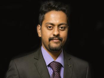 Scientist in a nice suit and collared shirt with tie smiling for the camera