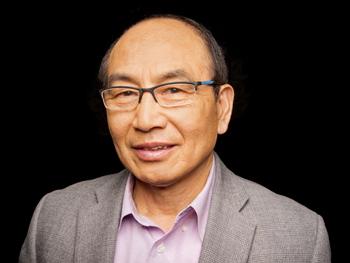 Asian male scientist wearing a light grey jacket and button-down shirt