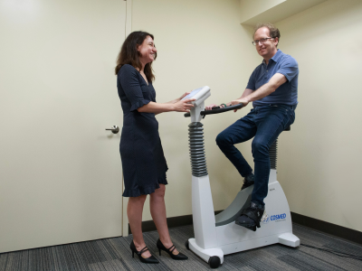Dan Richter on an exercise bike with Olga Boukrina, PhD observing.