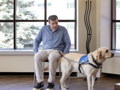 John McAleavey and his K9 companion sitting in a bright light filled room