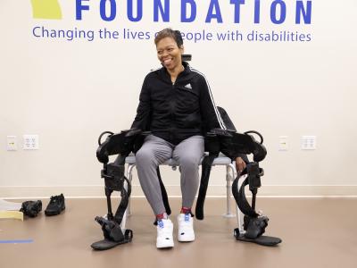 Woman sits on a bench with a robotic exoskeleton