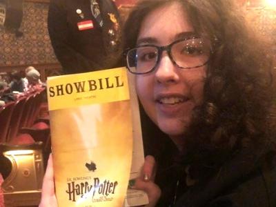 holly holding a playbill in the theater
