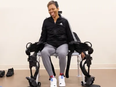Woman sits on a bench with a robotic exoskeleton