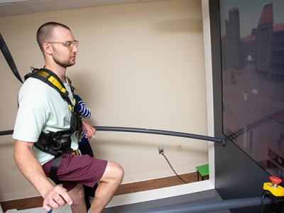 participant walking on C-Mill treadmill using augmented reality