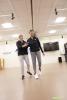 Women walking in a rehabilitation setting with a physical therapist supporting her